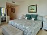 Stone-finish flooring throughout, recessed ceiling lighting, and a full-length floor mirror with a black frame