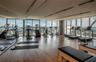 Fitness space featuring floor-to-ceiling windows, wood-finish flooring, full-wall mirrors, and recessed track lighting