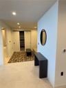 Built-in closet with sliding doors and integrated shelving, recessed lighting, and neutral stone-finish flooring