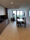 Modern kitchen featuring wood-finish cabinetry, built-in stainless steel oven, stone-surface countertops, recessed ceiling lighting, and floor-to-ceil