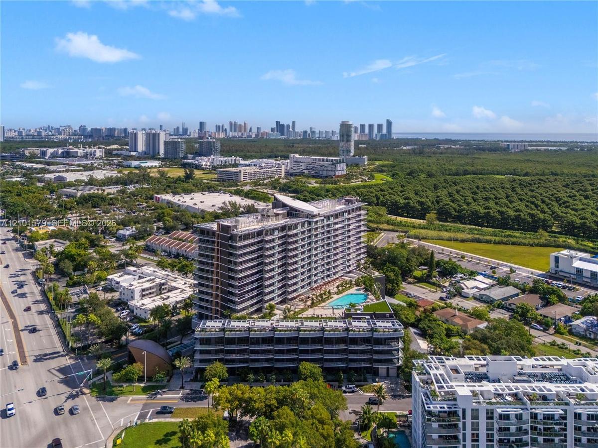 Aerial view of high-rise residential structure featuring an expansive terrace level, outdoor swimming pool, and proximity to expansive natural greener