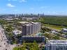 Aerial view of high-rise residential structure featuring an expansive terrace level, outdoor swimming pool, and proximity to expansive natural greener