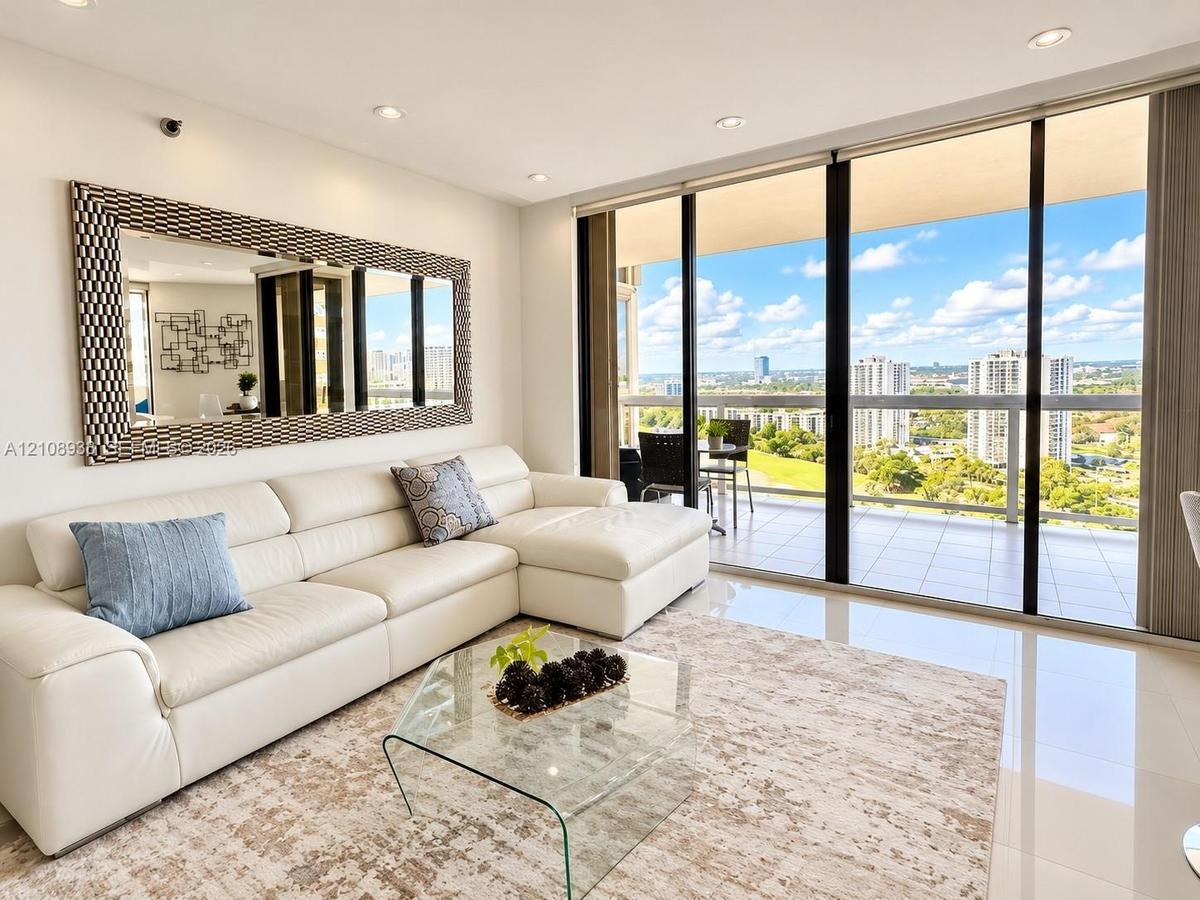 Floor-to-ceiling sliding glass doors, private balcony, polished tile flooring, and recessed ceiling lighting