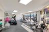 Fitness center featuring modular floor tiling, floor-to-ceiling windows, and recessed ceiling lighting