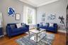 Room featuring high ceilings with crown molding, tall multi-pane window, and wood-finish flooring