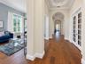 Foyer featuring wood-finish flooring, recessed tray ceilings, arched entryways, and white-trimmed glass-paneled French doors