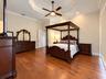Tray ceiling featuring recessed lighting and a central ceiling fan, complemented by wood-finish flooring