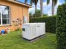 Whole-house standby generator situated on a concrete pad within the side yard - 1000 gallons