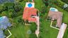 Aerial perspective featuring a multi-gabled residence with a terracotta tile roof, an expansive landscaped lawn, a private swimming pool with concrete