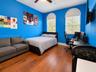 Room featuring wood-finish flooring, two arched windows with decorative transoms, and a ceiling fan