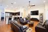 Open concept interior featuring wood-finish flooring, recessed lighting, crown molding, and a kitchen with dark cabinetry and a breakfast bar