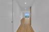 Hallway featuring wood-finish flooring, recessed lighting, and floor-to-ceiling glass sliding doors