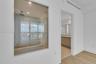 Interior space featuring wood-finish flooring, a glass-enclosed soaking tub with a ceiling-mounted rainfall showerhead, and dual-vanity cabinetry with