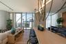 Open-concept living area featuring wood-finish flooring, floor-to-ceiling glass doors, and a linear track lighting system