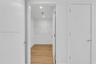 Storage space featuring wood-finish flooring, white walls, recessed ceiling lighting, and wire shelving