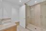 Modern bathroom featuring a wood-finish vanity with a solid-surface countertop, an integrated rectangular sink, a glass-enclosed walk-in shower with f