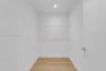 Storage space featuring wood-finish flooring, white walls, recessed ceiling lighting, and built-in wire shelving