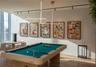 Modern light-filled room featuring wood-finish flooring, linear LED pendant lighting, and ceiling-mounted track lighting