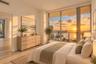 Expansive floor-to-ceiling windows, direct water scenery, light-toned tile flooring, recessed lighting, and a neutral color palette