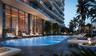 Outdoor swimming pool featuring stone-tile decking, full-height glass window walls, and manicured palm tree landscaping