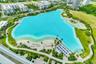 Large-scale turquoise lagoon featuring sandy shorelines, paved pedestrian pathways, manicured green space, and perimeter palm trees