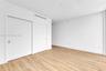 Interior space featuring wood-finish flooring, crisp white walls, and a large closet with sliding doors