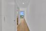 Hallway featuring wood-finish flooring, recessed lighting, and access to a balcony with an expansive exterior outlook