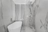 Freestanding soaking tub, walk-in shower, rain shower head, hand-held shower, and wall-mounted plumbing fixtures, all surrounded by large-format porce