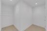 Walk-in storage space featuring wood-finish flooring, white walls, recessed ceiling lighting, and wire shelving