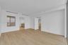 Interior space featuring wood-finish flooring, white walls, and a large window