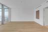 Interior space featuring floor-to-ceiling glass sliding doors, wood-finish tile flooring, recessed linear air conditioning vents, and a neutral color 
