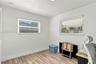 Room featuring wood-finish flooring, neutral walls, and dual windows with horizontal blinds