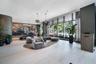 Expansive floor-to-ceiling windows, light-toned tile flooring, recessed ceiling lighting, and a valet station