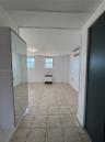 Neutral-toned tile flooring, dual windows, wall-mounted ductless climate control unit, and mirrored built-in closet