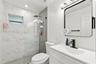 Bathroom featuring a vanity with a white composite countertop, integrated rectangular sink, and matte black faucet