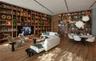 Floor-to-ceiling custom wood shelving with integrated lighting, wood-finish flooring, and minimalist track lighting