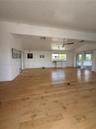 Open-concept living space featuring wood-finish flooring, vaulted ceilings, recessed lighting, a ceiling fan, and sliding glass doors