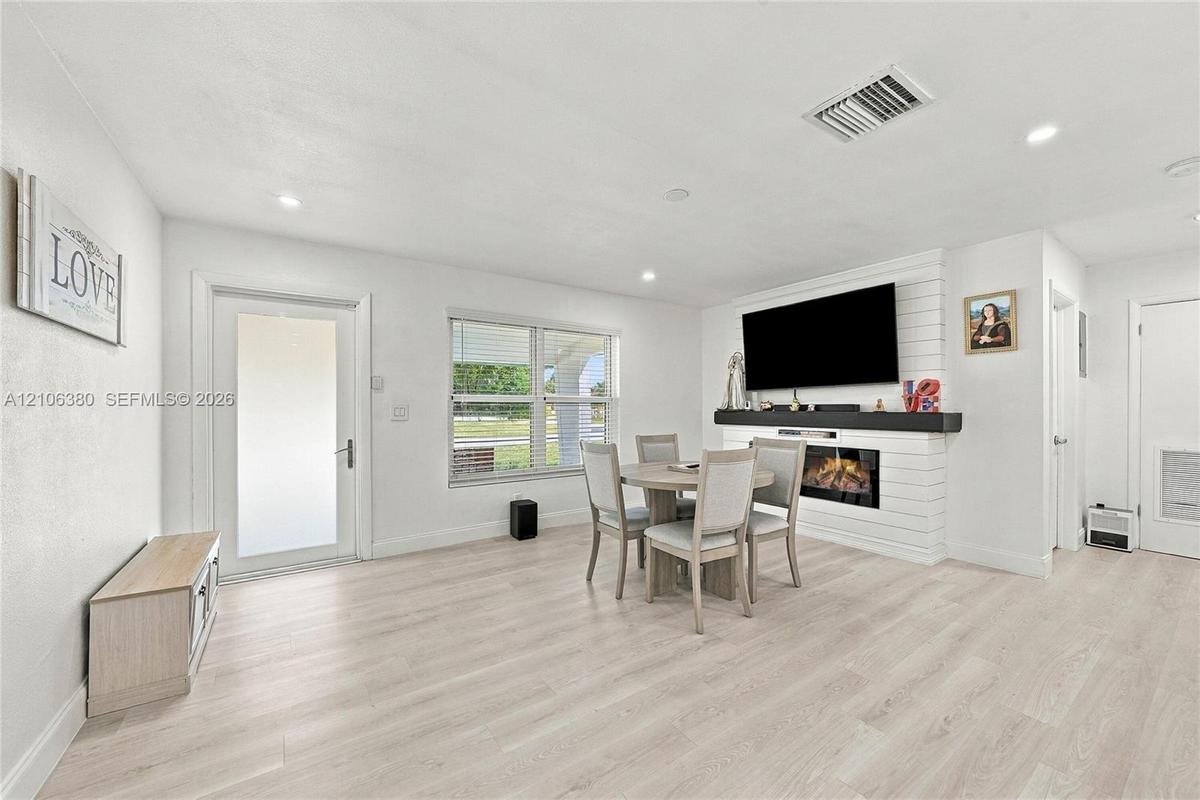 Living area featuring wood-finish flooring, recessed lighting, and a fireplace with a white shiplap surround and a dark wood mantel