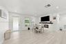 Living area featuring wood-finish flooring, recessed lighting, and a fireplace with a white shiplap surround and a dark wood mantel