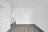 Interior space featuring wood-finish flooring, crisp white wall finishes, and a traditional-style interior door