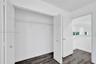 Interior closet featuring white paneled bifold doors, wire shelving, and wood-finish flooring