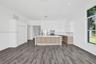 Kitchen featuring white flat-panel cabinetry, wood-finish lower cabinets, stone-surfaced kitchen island, wood-finish flooring, and recessed lighting