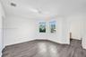 Room featuring wood-finish flooring, a multi-paneled bay window, and a ceiling-mounted light fixture