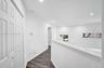 Hallway featuring wood-finish flooring, recessed lighting, and a white bi-fold closet door