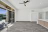 Open-concept space featuring wood-finish flooring, a kitchen island with stone-style countertop and light wood cabinetry, recessed lighting, and a mul