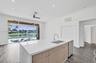 Kitchen featuring a center island with a quartz countertop, stainless steel undermount sink, built-in dishwasher, wood-finish cabinetry, and wood-fini