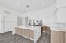 Kitchen featuring a central island with a solid-surface waterfall countertop, wood-finish cabinetry, stainless steel appliances, and wood-finish floor