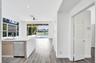 Kitchen area featuring a quartz countertop island, stainless steel dishwasher, wood-finish flooring, recessed lighting, and expansive glass sliding do