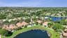 Aerial perspective of a property featuring a swimming pool, screened-in lanai, and waterfront positioning on a lake