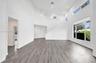 Vaulted ceilings, wood-finish flooring, recessed lighting, multi-level windows, and a staircase with a solid partition wall